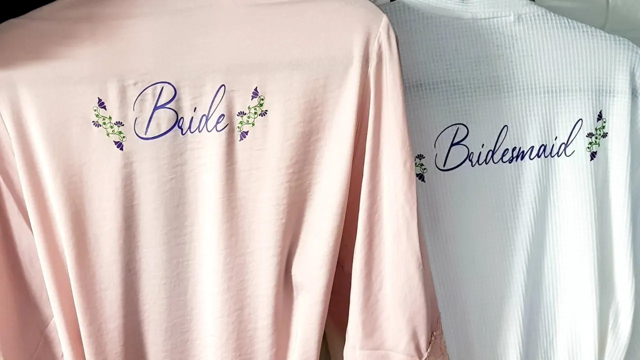 Pink and white robes printed with Bride and Bridesmaid in purple script