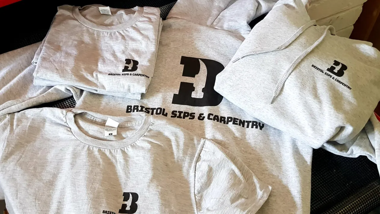 Grey t-shirts and hoodies printed with the Bristol SIPS and Carpentry logo