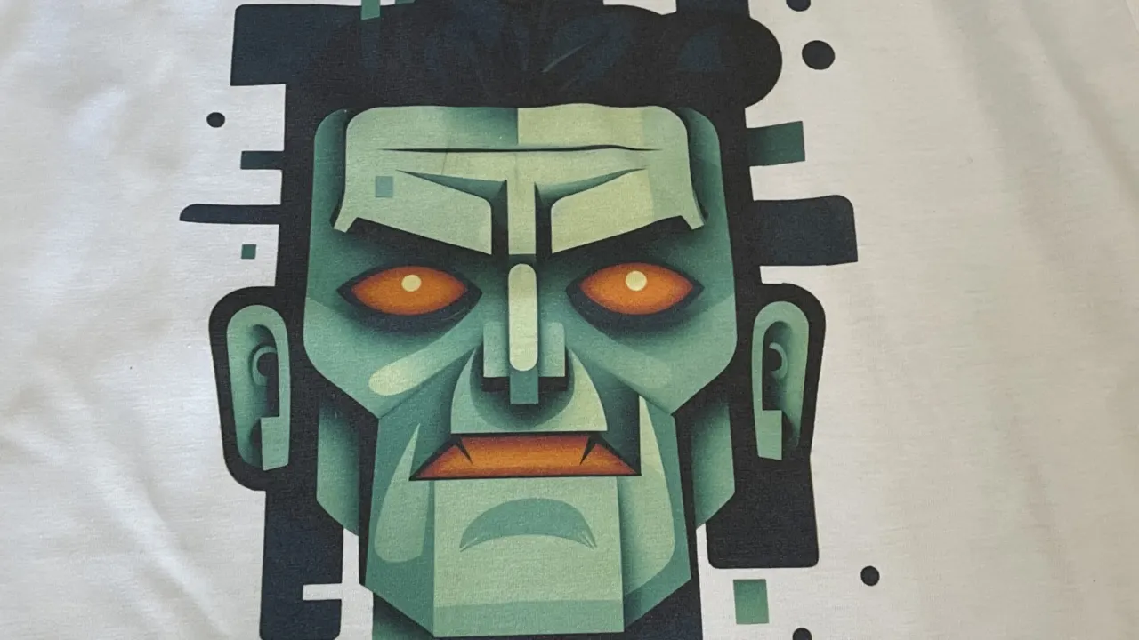 A full colour cartoon face design printed on a white t-shirt